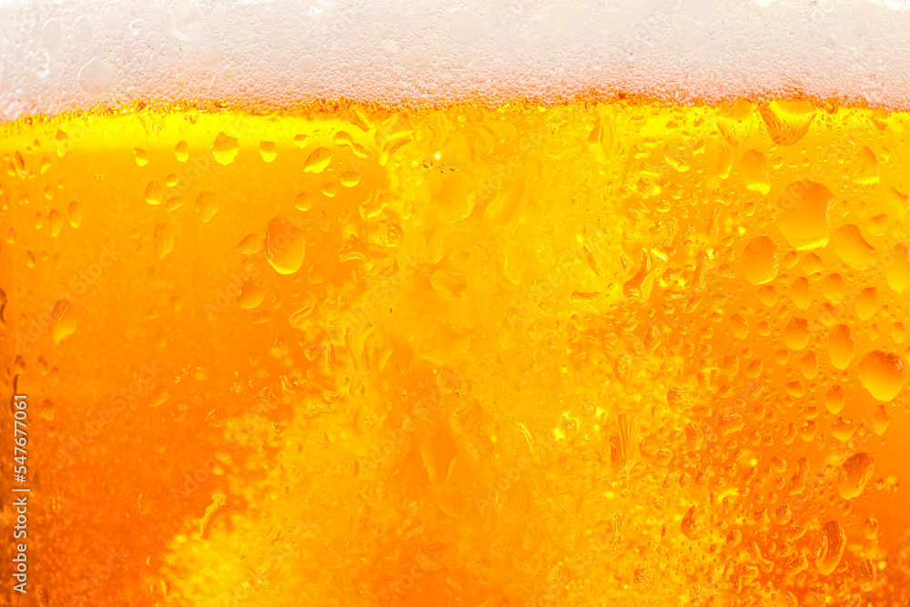 Glass of tasty cold beer with foam and condensation drops as background, closeup Glass of tasty cold beer with foam and condensation drops as background, closeup