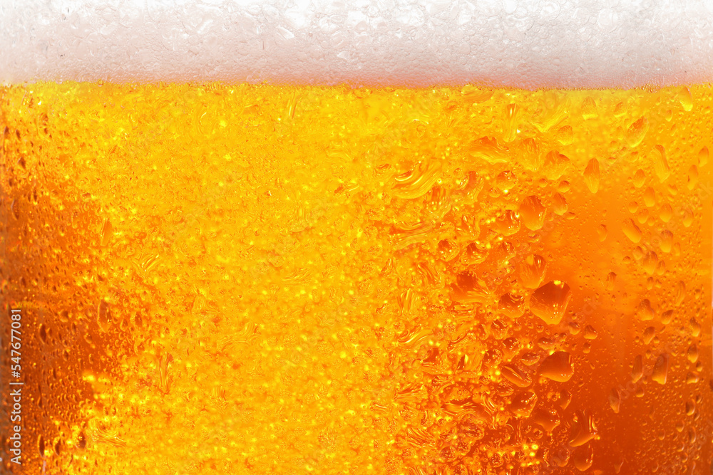 Glass of tasty cold beer with foam and condensation drops as background, closeup Glass of tasty cold beer with foam and condensation drops as background, closeup