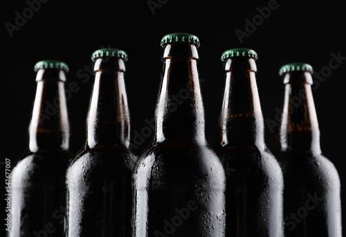 Many bottles of beer on black background, closeup