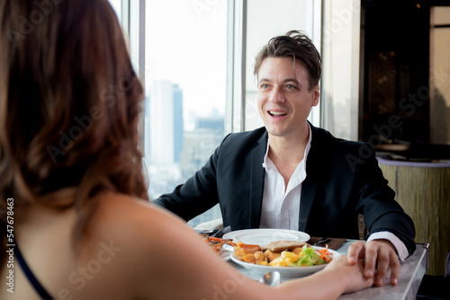 Happy young couple date with romance together in anniversary at restaurant luxury for celebrate  man proposal woman for marriage while dining in atmosphere romantic  two people  valentine concept.
