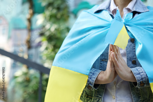 Woman holding national flag of Ukraine outdoors, closeup. Space for text