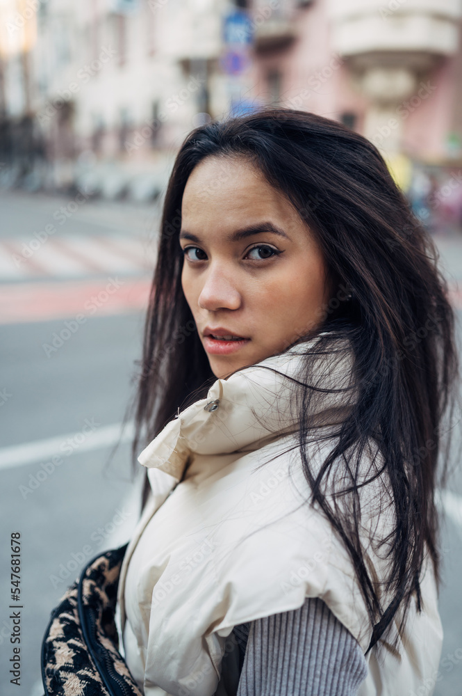 Close-up portrait of a beautiful hispanic woman standing in the evening on the street and looking at the camera with a serious face. Close-up portrait of a beautiful hispanic woman standing in the evening on the street and looking at the camera with a serious face.