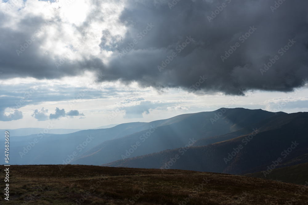 Beautiful view of the carpathian moun landscape with green meadows, trees, dark low clouds on the mountains in the background. travel destinations.