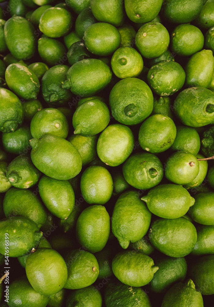 Lots of green lemons close up. Fruit tropical pattern. Fresh juice. Local food market. 