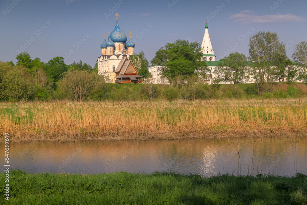 Wooden Church of St. Nicholas near Kremlin with river at sunset, Suzdal, Russia