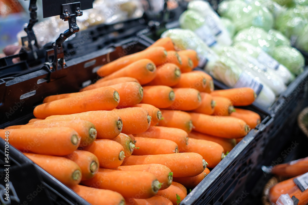 Bunch of carrots, Lots of orange carrots placed on a black shelves in supermarket. in the food zone from agricultural produce in the department store, side view Bunch of carrots, Lots of orange carrots placed on a black shelves in supermarket. in the food zone from agricultural produce in the department store, side view