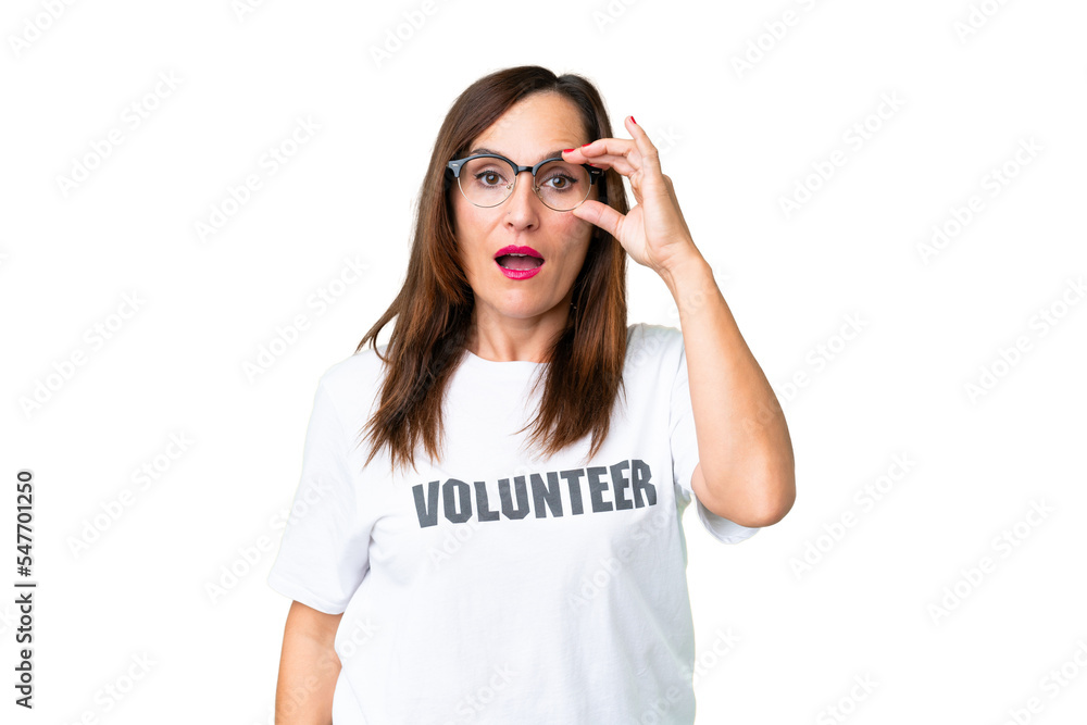 Middle age volunteer woman over isolated chroma key background with glasses and surprised Middle age volunteer woman over isolated chroma key background with glasses and surprised