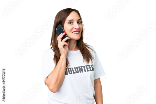 Middle age volunteer woman over isolated chroma key background keeping a conversation with the mobile phone