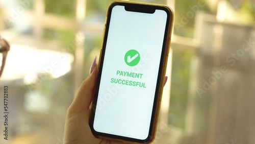 A woman's hand holds a smartphone on screen with the message money sent and received. Concept of financial transactions with mobile devices. Closeup, money, transfer, phone, Payment. Cafe background