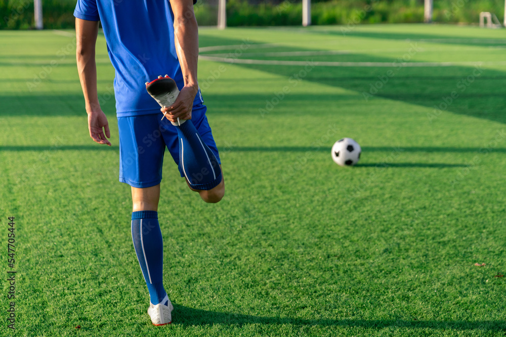 football soccer player stretching during warm up before kick ball in