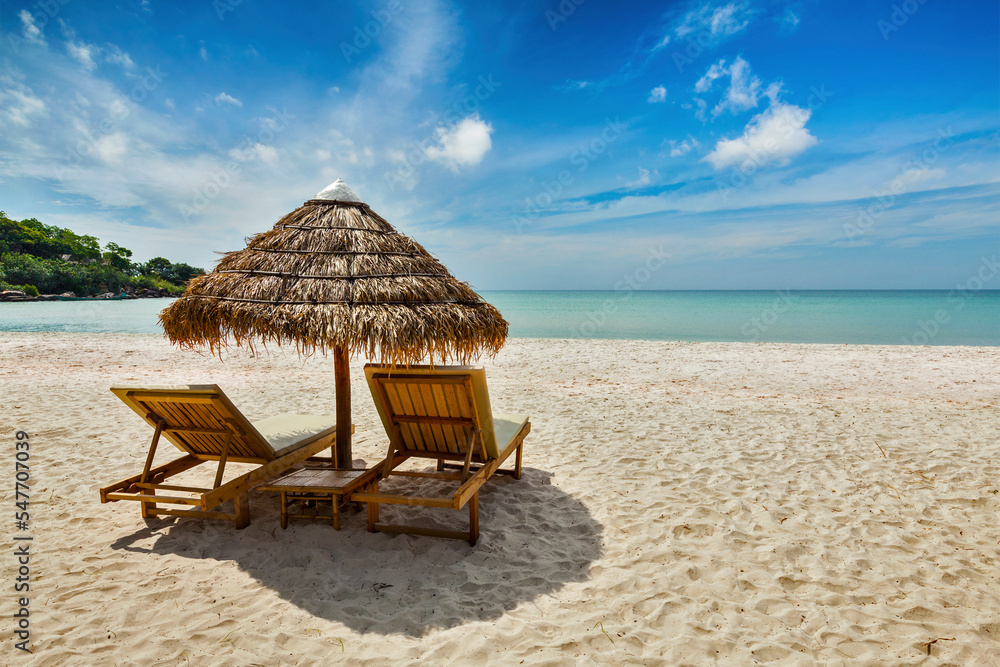 Fototapeta premium Vacation holidays beach concept - Two beach lounge chairs under tent on beach. Sihanoukville, Cambodia