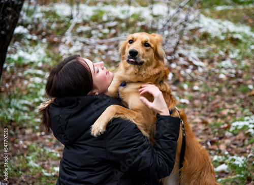woman hugging dog in winter park