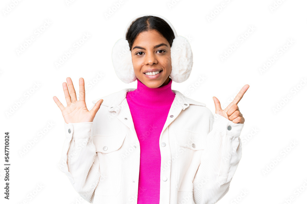 Young African American woman wearing winter muffs over isolated chroma key background counting seven with fingers Young African American woman wearing winter muffs over isolated chroma key background counting seven with fingers