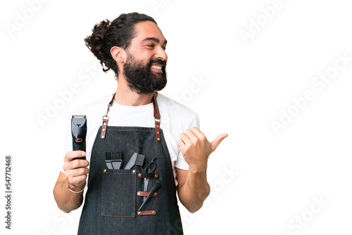 Young barber man over isolated chroma key background pointing to the side to present a product photo