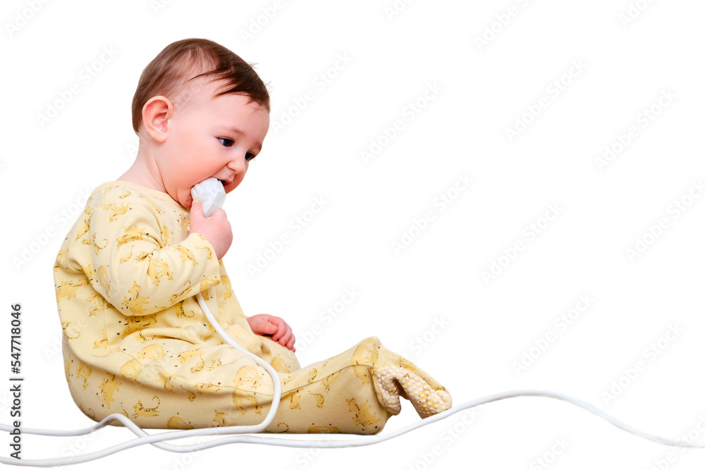 Toddler baby boy gnaws electrical wires while sitting on the floor, isolated on a white background. Child holding an extension cord with electrical sockets, copy space. Kid nine months old Toddler baby boy gnaws electrical wires while sitting on the floor, isolated on a white background. Child holding an extension cord with electrical sockets, copy space. Kid nine months old