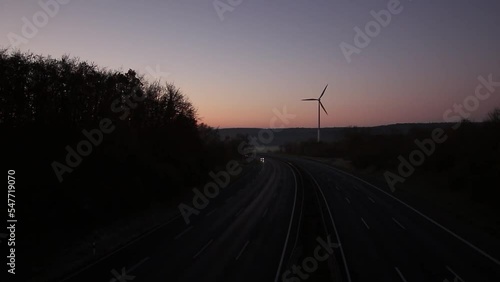 Time lapse of a morning sunrise over the Highway with a winmill in the background photo