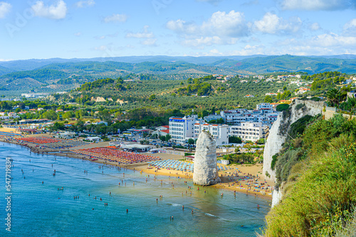 Vieste, Italy. Panoramic view from the top of the Lungomare Enrico Mattei beach with the famous Pizzomunno Monolith rising into the sea. September 5, 2022. photo