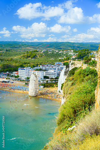 Vieste, Italy. Panoramic view from the top of the Lungomare Enrico Mattei beach with the famous Pizzomunno Monolith rising into the sea. Vertical image. September 5, 2022. photo