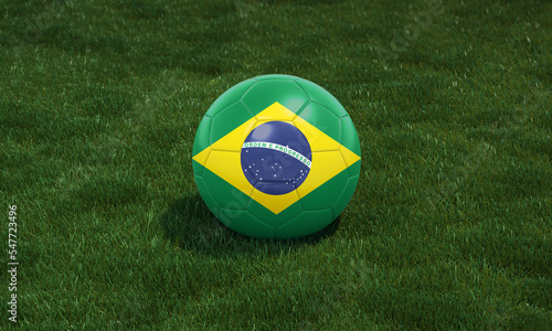 Soccer ball with Brazil flag colors at a stadium on green grasses background.