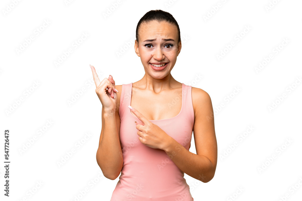 Young Arab woman over isolated background frightened and pointing to the side Young Arab woman over isolated background frightened and pointing to the side