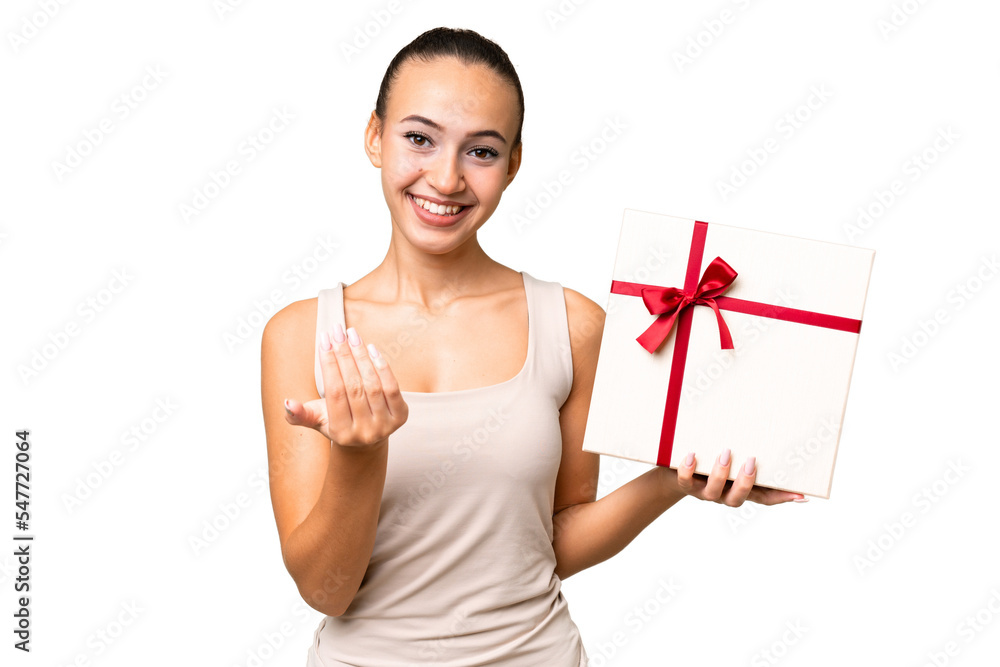 Young Arab woman holding a gift over isolated background inviting to come with hand. Happy that you came Young Arab woman holding a gift over isolated background inviting to come with hand. Happy that you came