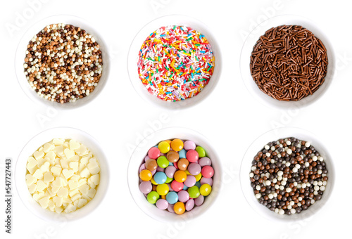 Sugar and chocolate sprinkles, in white bowls. Tiny chocolate balls, nonpareils, rod-shaped sugar and choco sprinkles, white choco hearts, and colorful button-shaped candies. Decoration and toppings. photo