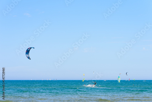 Vieste, Italy. In the sea of Scialmarino beach, a young man kitesurfing. In the background windsurfers and kitesurfers. September 7, 2022 photo