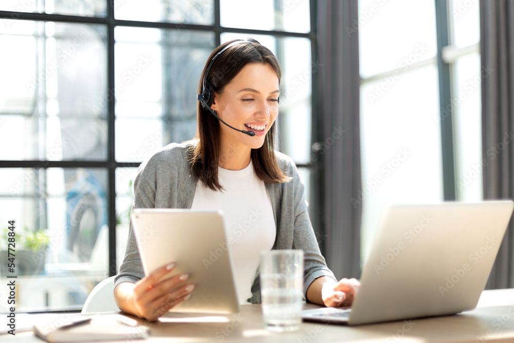 Freelance operator talking with headsets and consulting clients from office Freelance operator talking with headsets and consulting clients from office