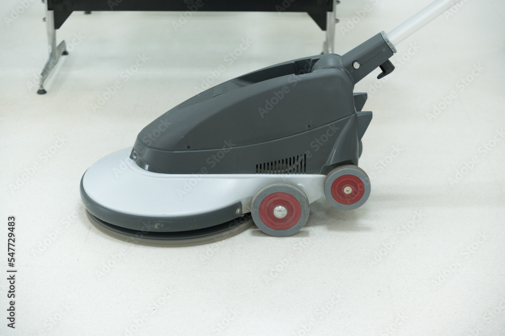 Woman maid cleaning floor with machine cleaner in the business office.Big cleaning day.Floor care with machine in hospital. Woman maid cleaning floor with machine cleaner in the business office.Big cleaning day.Floor care with machine in hospital.