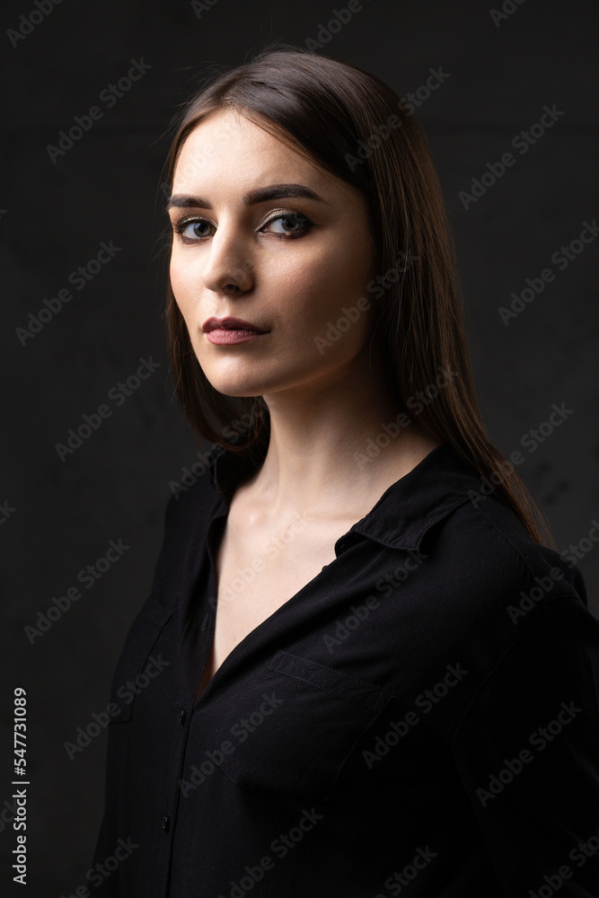 Portrait of a young brunette with long hair in the studio. Dramatic photo in dark colors. Portrait of a young brunette with long hair in the studio. Dramatic photo in dark colors.
