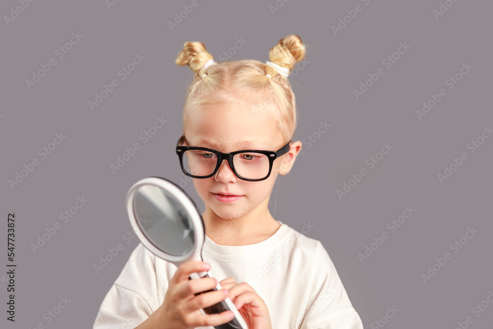The girl looks through a magnifying glass, glass to magnify objects, science, early childhood development, preparation for school, learning physics, viewed through a magnifying glass.
The girl looks through a magnifying glass, glass to magnify objects, science, early childhood development, preparation for school, learning physics, viewed through a magnifying glass.