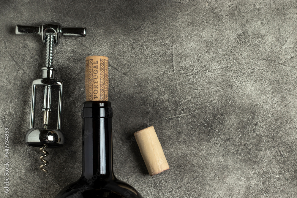 Portuguese wine. Bottle, corkscrew and cork on a black background. Portuguese wine. Bottle, corkscrew and cork on a black background.