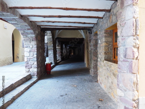 antiguo porche medieval con arcos de medio punto  separados por robustas conlumnas de piedra  techo de cal blanca y vigas de madera   pont de suert  lerida  espa  a  europa