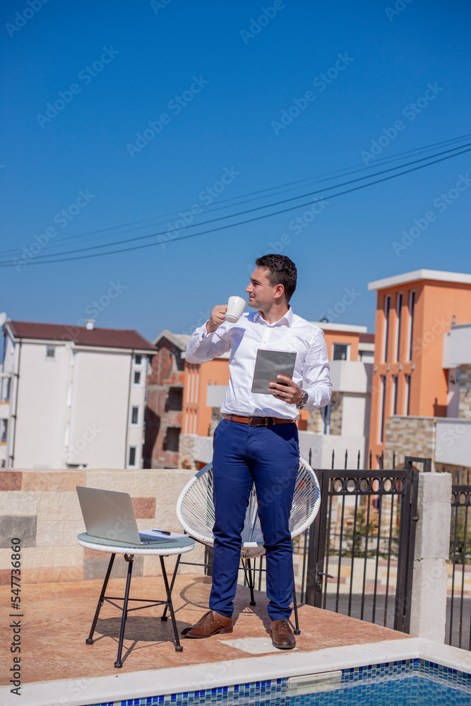 Adult businessman using laptop and phone Adult businessman using laptop and phone