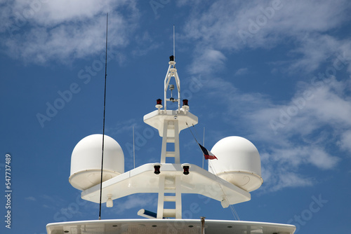 Close up on naval transmission, radio communication devices on a boat, a luxury yacht, including antenna, radio, as well as beacon and radio equipment.
