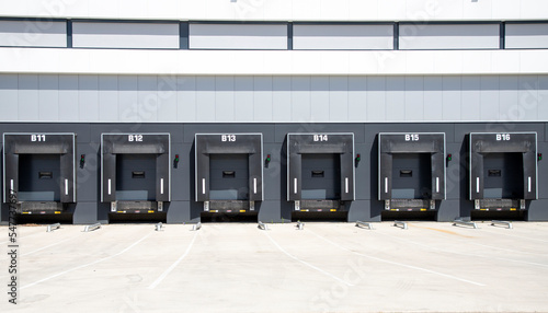 Row of loading docks with shutter doors at warehouse. Row gate.