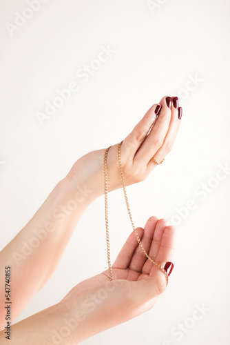 Women's hands holding a golden chain