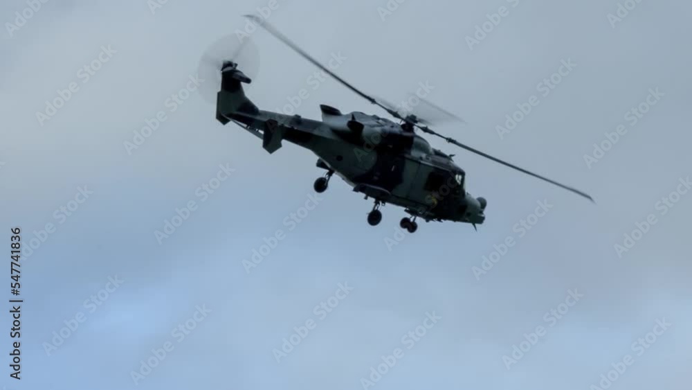 British army AgustaWestland AW159 Wildcat AH1 helicopter banking in a blue grey sky, Wilts UK British army AgustaWestland AW159 Wildcat AH1 helicopter banking in a blue grey sky, Wilts UK