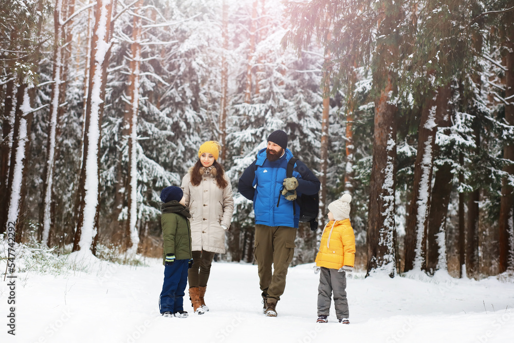 Happy family playing and laughing in winter outdoors in the snow. City park winter day.