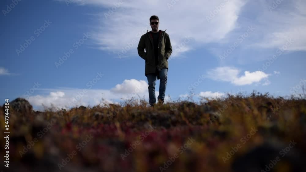 Caucasian man with green coat and sunglasses in a field Caucasian man with green coat and sunglasses in a field