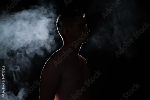 silhouette of a guy. men in the dark. smoke . steam . man in a dark room.