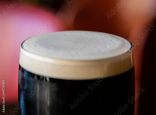 Closeup of foamy pint glass filled with porter