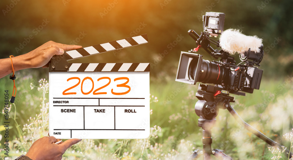 Flim In Camera 2023- handwritten on film clapperboard. film crew holding film ...