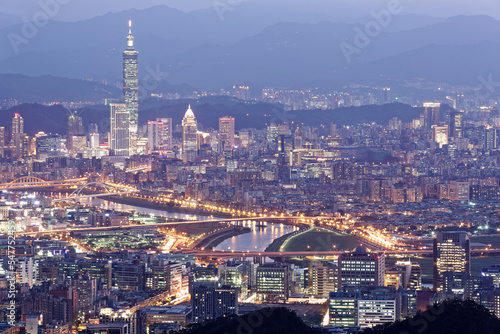 Aerial panorama of Taipei downtown and suburbs at dusk with view of Keelung Riverside Park  MacArthur bridge and 101 Tower in Xinyi District. A romantic night in busy Taipei City in a gloomy blue mood