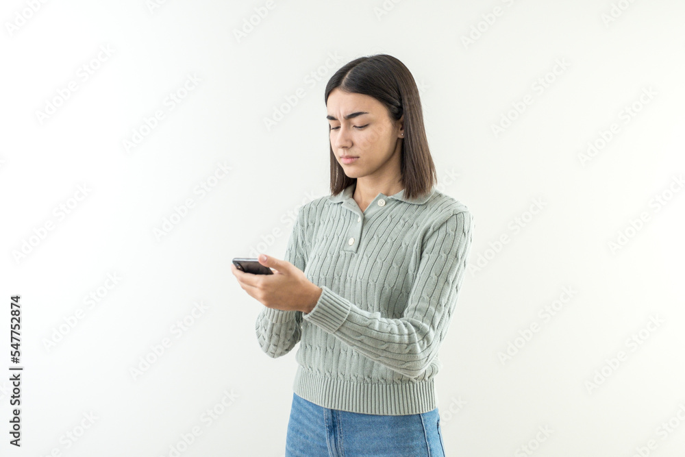 Confused and angry young girl with short hair looking at phone. Confused and angry young girl with short hair looking at phone.