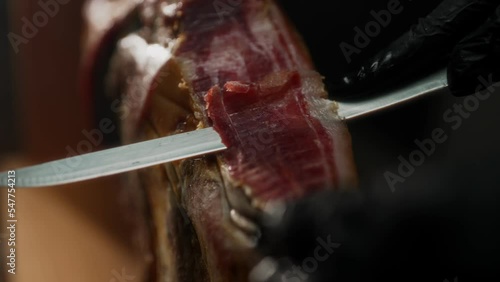 Chef cutting dry-cured spanish ham Jamon.