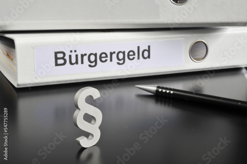 Hamburg, Germany - November 20, 2022: A paragraph sign in front of an office folder titled Bürgergeld the new system for financial support for unemployment in Germany