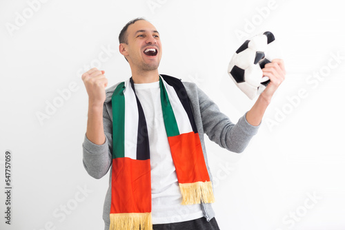 Joyful happy young man in shirt posing background. People sincere emotions lifestyle concept. Mock up copy space. Holding soccer ball doing winner gesture screaming photo