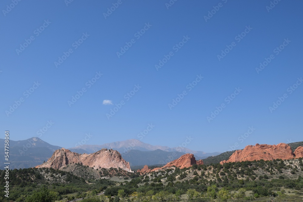 Naklejka premium Distant view of Garden of the Gods and Pikes Peak against clear blue sky with haze from California forest fires in the Colorado mountains