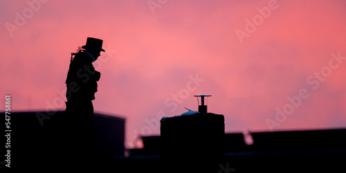 Schilderij op canvas Silhouette eines Kaminkehreres vor rotem Abendhimmel